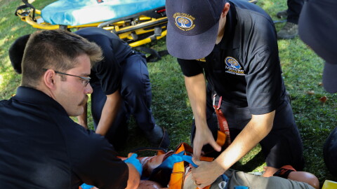 Cameron Loureiro, left, puts spider straps on a dummy patient who has lost limbs during an emergency call scenario.