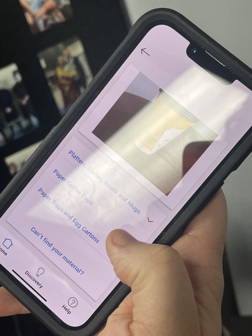 Tazewell County Health Communication Specialist JD Raucci demonstrates the photo function of Recycle Coach by taking a picture of a paper coffee cup. The app provides categories of items and then breaks down disposal instructions from there.