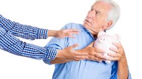 Senior man protecting his piggy bank savings from being stolen