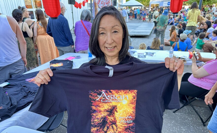 Woman holding up t-shirt. 