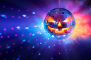 A mirrored disco ball with a glowing jack-o'-lantern face hangs against a colorful background of blue, purple, pink and orange lights.