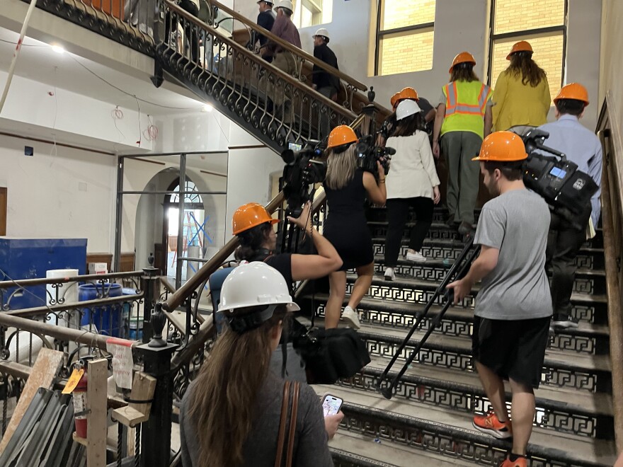 Media and others head up an original iron staircase to the second floor.