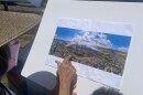 Jean Souza, who lives in Hanapēpē Heights, points at an image aftermath of the July 2024 Kaumakani fire.