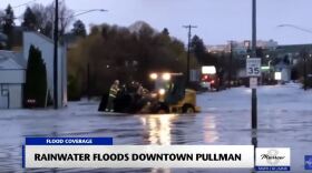 Evacuation crews help a resident get away from the flood water