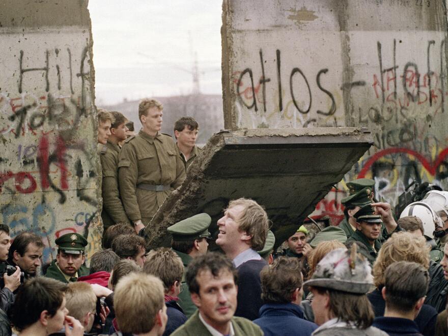 West Berliners crowd in front of the Berlin Wall on Nov. 11, 1989, as they watch East German border guards demolishing a section of the wall in order to open a new crossing point between East and West Berlin.