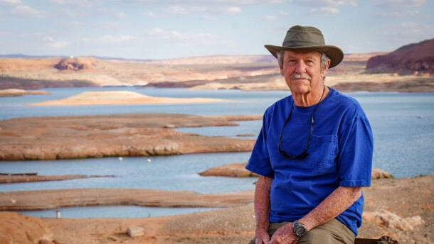 Bill Adams leans against a concrete dock anchor on a cliff overlooking the Bullfrog Marina, April 27, 2026. Adams has seen Lake Powell change a lot in the five decades he’s been visiting Bullfrog.