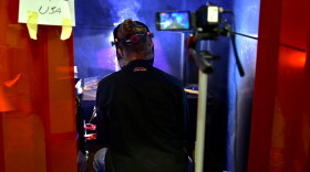 A student at the Elkhart Area Career Center welds a design for the SkillsUSA competition while being recorded on camera.