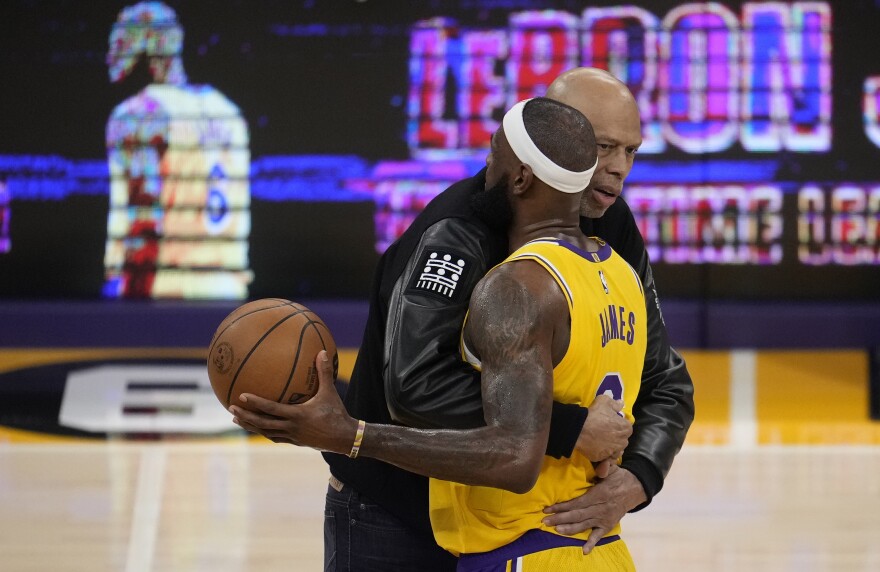 Kareem Abdul-Jabbar, left, hugs Los Angeles Lakers forward LeBron James after he surpassed Abdul-Jabbar to become the NBA's all-time leading scorer during the second half of an NBA basketball game against the Oklahoma City Thunder on  Tuesday in Los Angeles.