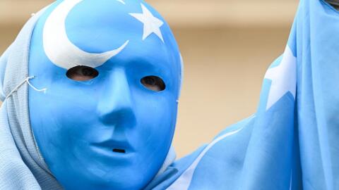 A protester wearing a mask bearing the Uighur flag takes part in a "theatrical" demonstration called by members of the Uighur community to protest against the state visit of China's President to France, at The Place de la Madeleine in Paris on May 5, 2024. China's President Xi Jinping is due to arrive in the French capital for a state visit to France on May 6 and 7. (Stefano Rellandini/AFP via Getty Images)