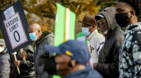 Flint residents Sherman Williams, left, and Johnny Brown, center right, protest alongside more than a dozen others calling for the resignation of Treasurer Gayle Armstrong on Thursday, Nov. 4, 2021, outside the Mount Morris Township, Mich., offices. MLive-The Flint Journal says Armstrong told the newspaper she called township Chief Financial Officer Greg Eason a “boy” during a conversation with township Supervisor Jolena Sims. Armstrong, who is white, said it wasn’t meant as a racial slur