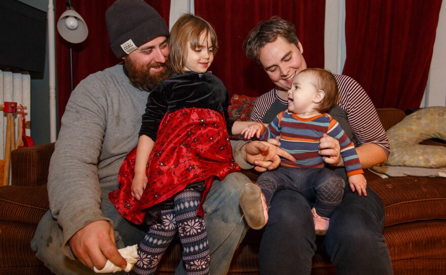 The Siebers family, now relaxed, on the living room couch that limited their world for several months when Margaret was on bed rest. Today both parents have returned to full-time paid work.
