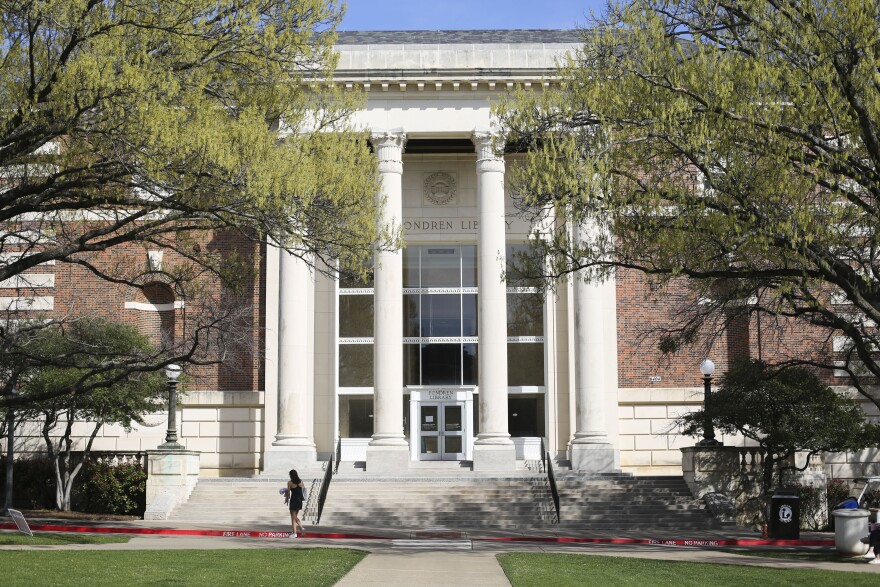 A student walks in front of the Fondren Library, which houses the archives, Monday, March 6, 2023, at Southern Methodist University in Dallas.