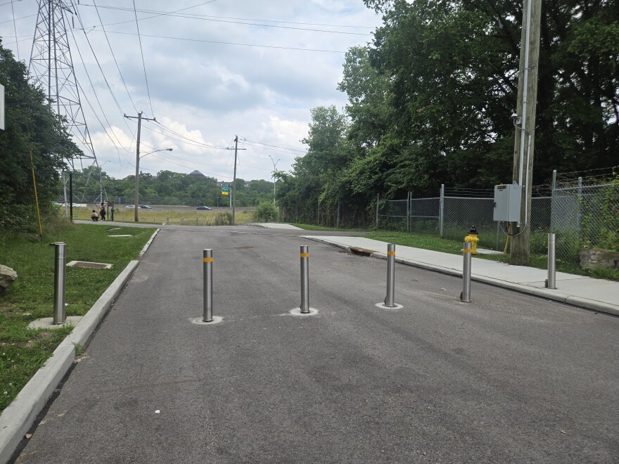 A bike path separated from vehicular traffic by metal poles. 