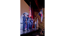 The Glenwood Springs High School JROTC Color Guard present on stage while Kylie Zajac sings the national anthem.