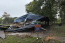 Photo shows a half crushed park pavilion and a park sign.