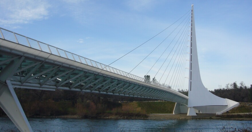 A white suspension bridge in Redding, California with a tall post on one side.