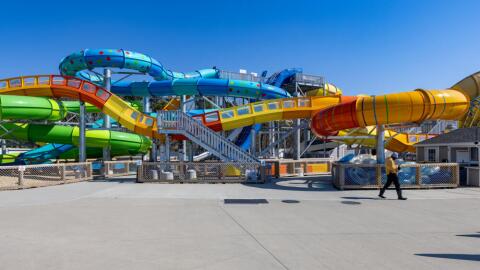 A maintenance worker walks past the water slide at Wicked Waves in Yarmouth as preparations are being made for the upcoming summer season. (Jesse Costa/WBUR)