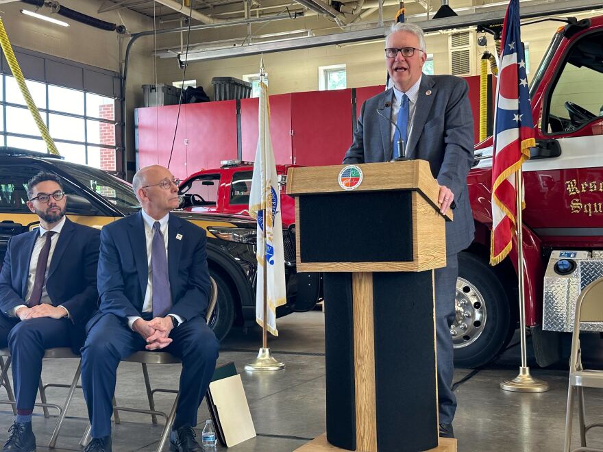 Cuyahoga County Executive Chris Ronayne speaks from a podium while Cleveland Heights Mayor Kahlil Seren and Shaker Heights Mayor David Weiss look on inside the Shaker Heights Fire Department on Tuesday, May 7, 2024.