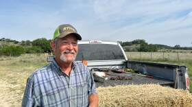 Chuck Schmidt, who helped his father fight screwworms, poses by his pickup at his property in central Texas.