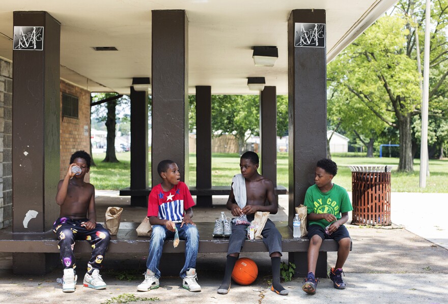 A group of STL Lunch regulars eat their turkey, bacon and cheese sandwiches at Hickey Park.