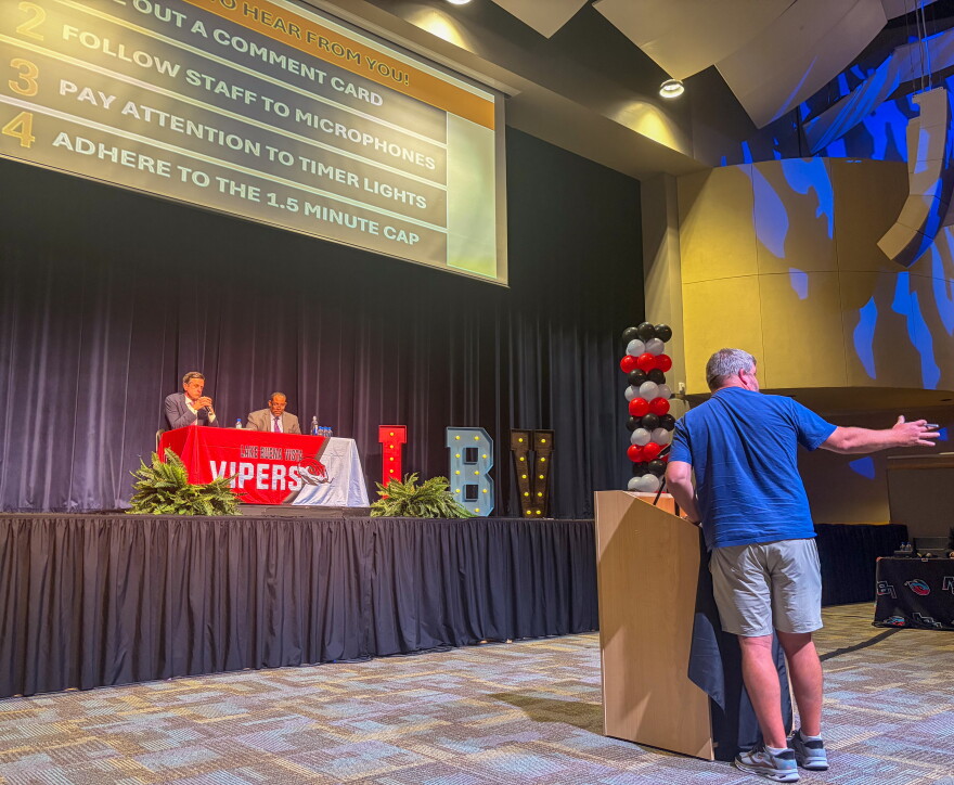 Middle school teacher Joshua Garrett gestures toward the audience while speaking about evolution during a public comment session on Florida’s proposed B.E.S.T. science standards. Garrett said the draft describes how organisms and Earth have changed over time but does not consistently name evolution as the scientific theory explaining those changes.