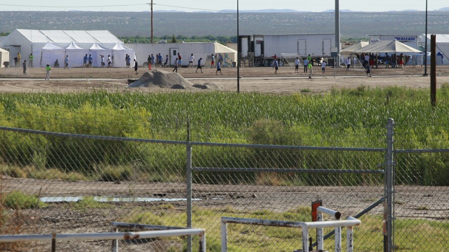 Detained migrant children play soccer at a newly constructed tent encampment as seen through a border fence near the U.S. Customs and Border Protection port of entry in Tornillo, Texas, on Monday.