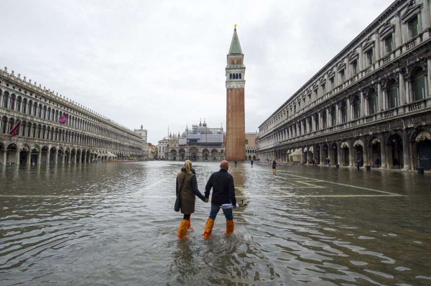 A couple walks in a flooded Saint Mark's Square during high waters on Nov. 19, 2013, in Venice, Italy.