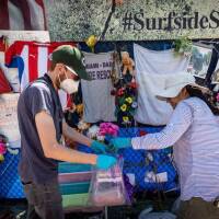 Workers for HistoryMiami bag items to be preserved from the Surfside memorial on Monday, August 30, 2021.