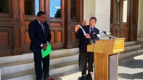 Sen. Richard Blumenthal at then podium with Perkin Simpson from Generation Power CT on the left and Christopher McCluskey from Community Renewal Team on the far right outside the State Capitol 0n October 6th 2026 talking about rising oil prices.