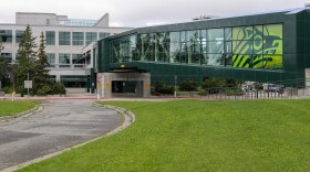 A lawn with an elevated pedestrian walkway over it.