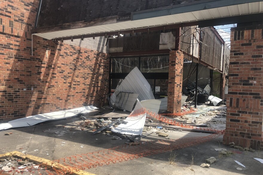 A grocery storefront blown out by Hurricane Ida last year stands abandoned in a Houma, La., strip center.