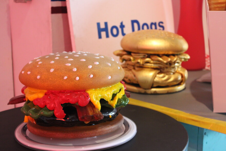 A supersized cheeseburger made of glass, as an art piece