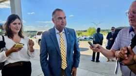 Gov. Mike Kehoe, center, speaks to reporters Thursday during a visit to Columbia Regional Airport.