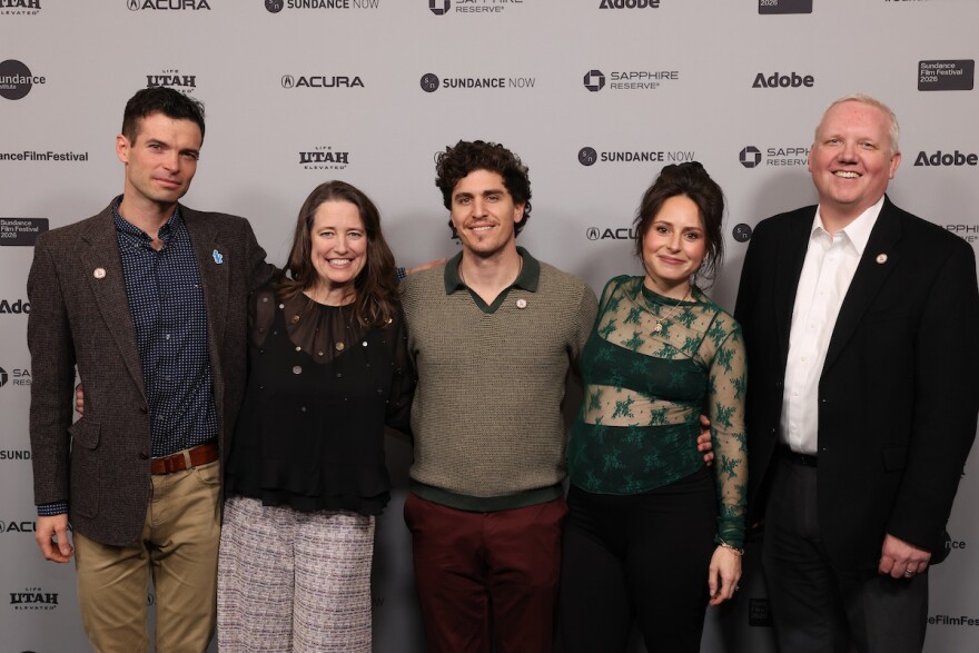 Five people stand side-by-side.