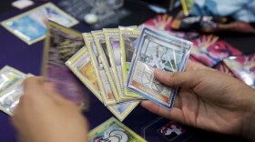 Competitor Jeffrey Chang from Washington state, reviews his hand, as he competes for a last chance qualifier spot in the Pokémon trading card game for the 2014 Pokémon World Championships in Washington, Friday, Aug. 15, 2014.