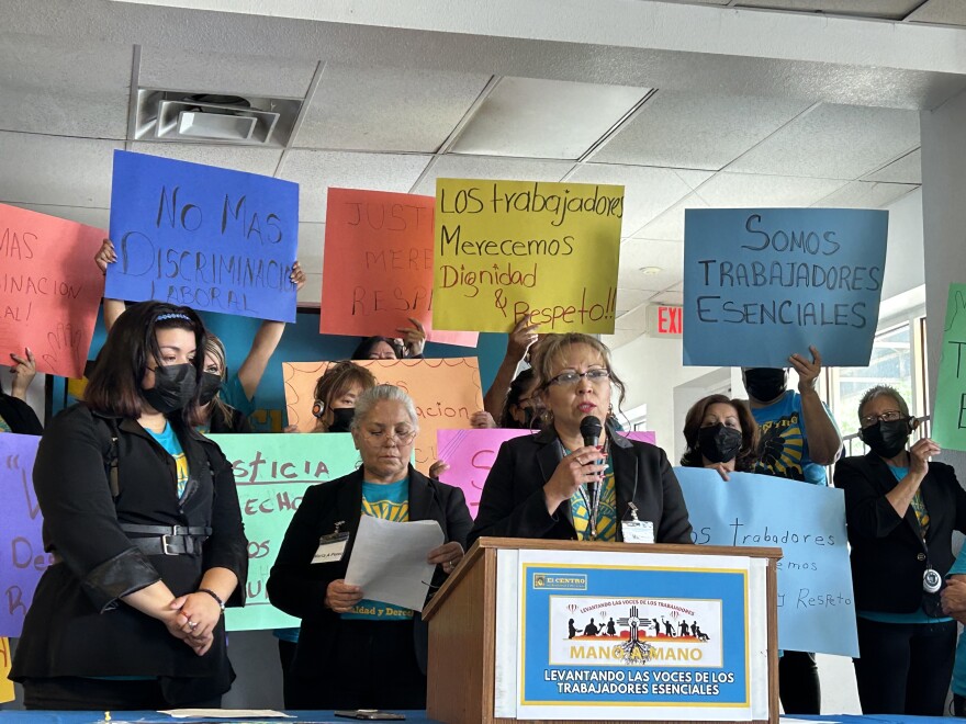 María Nevarez speaks at the podium about her experience working in the laundry room at the South Valley Care Center for nearly a decade. She says she experienced discrimination as a 50-year-old Spanish-speaker and retaliation, including being fired in August 2022. The EEOC and NLRB are investigating the claims.