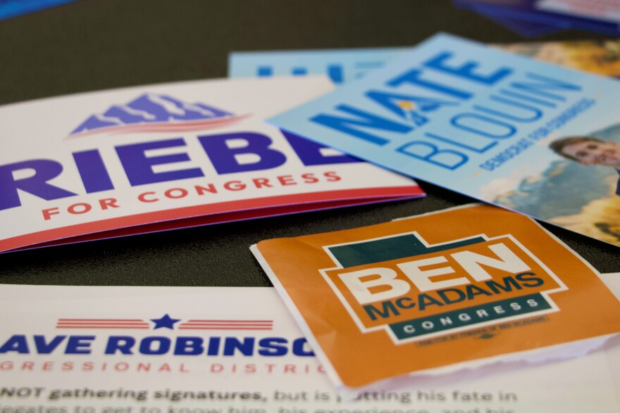 Candidate handouts are displayed at an event for candidates running to represent Utah's new Democratic-leaning congressional district, March 21, 2026, in Taylorsville, Utah.