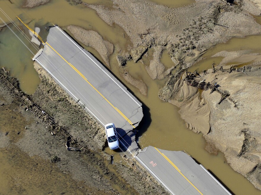An abandoned car lies off a road devastated by floodwaters along the South Platte River east of Greeley, Colo., on Sept. 17.