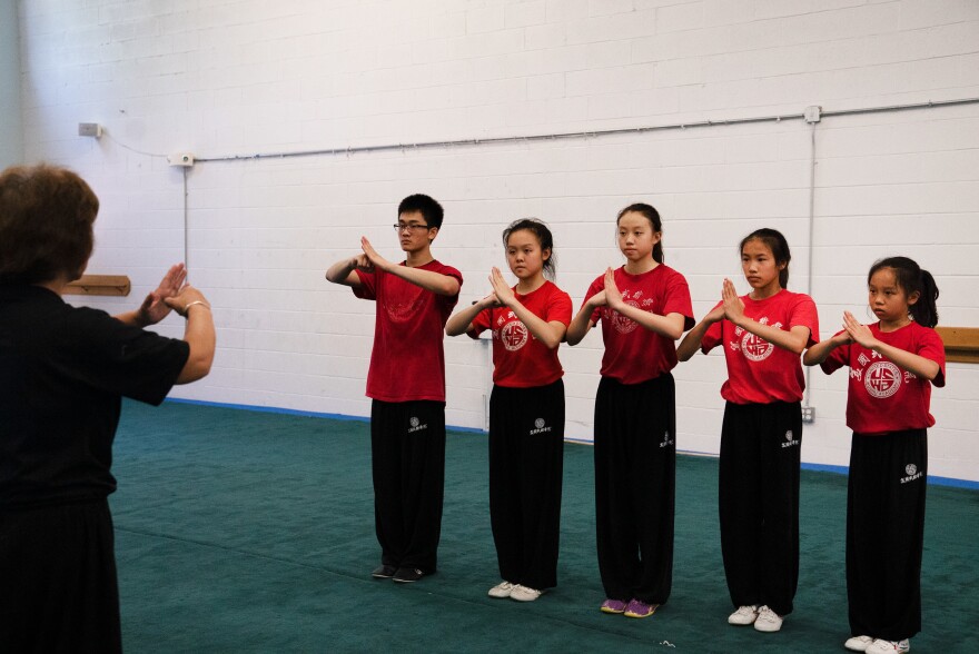Students greet Zhang before practice. She can be loud and strict, but often call her students Bǎo Bèi Er, or my baby, and her students call her Mā, or mom.