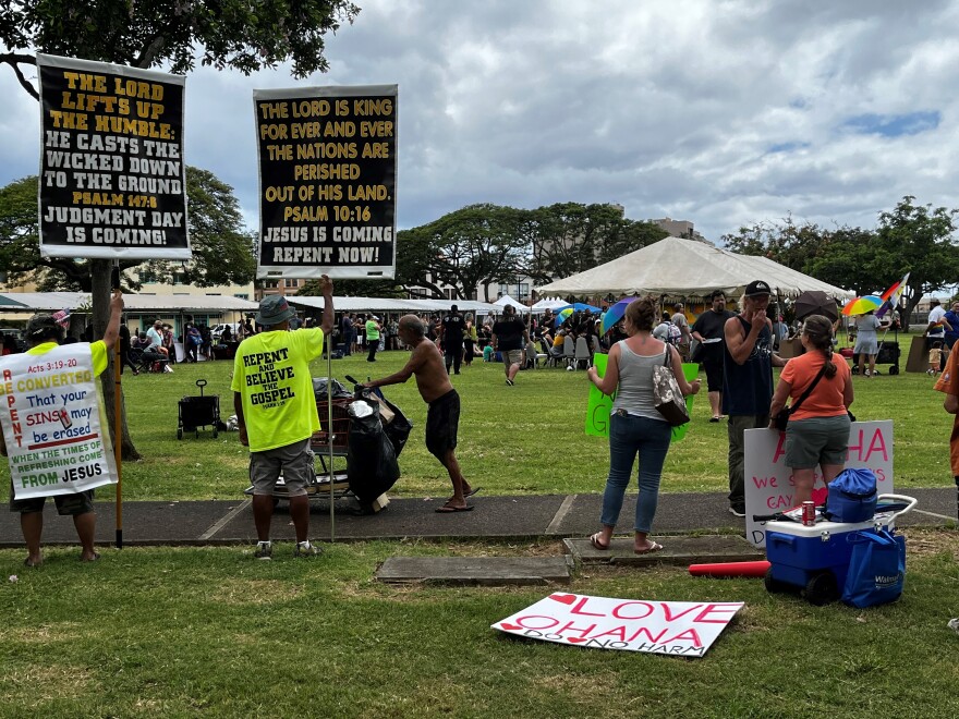 Protestors and counter-protestors circle around the park while drag queens read a story to children.