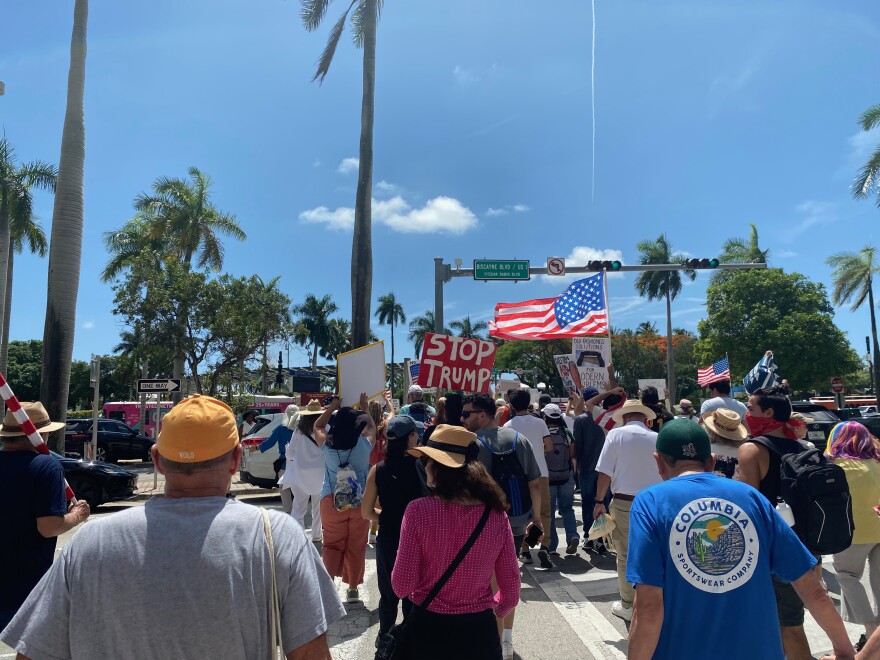 In downtown Miami, demonstrators lined Biscayne Boulevard in and around the Torch of Friendship, waving signs amid the sound of horns blaring from passing cars on Saturday, June 14, 2025, as part of nationwide "No Kings" protest.