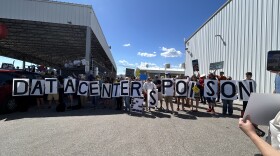A group of people hold up various letter signs, spelling out "Data centers poison"