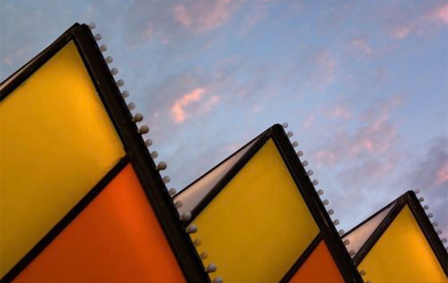 Three triangular windows pointing upwards on a cloudy sky