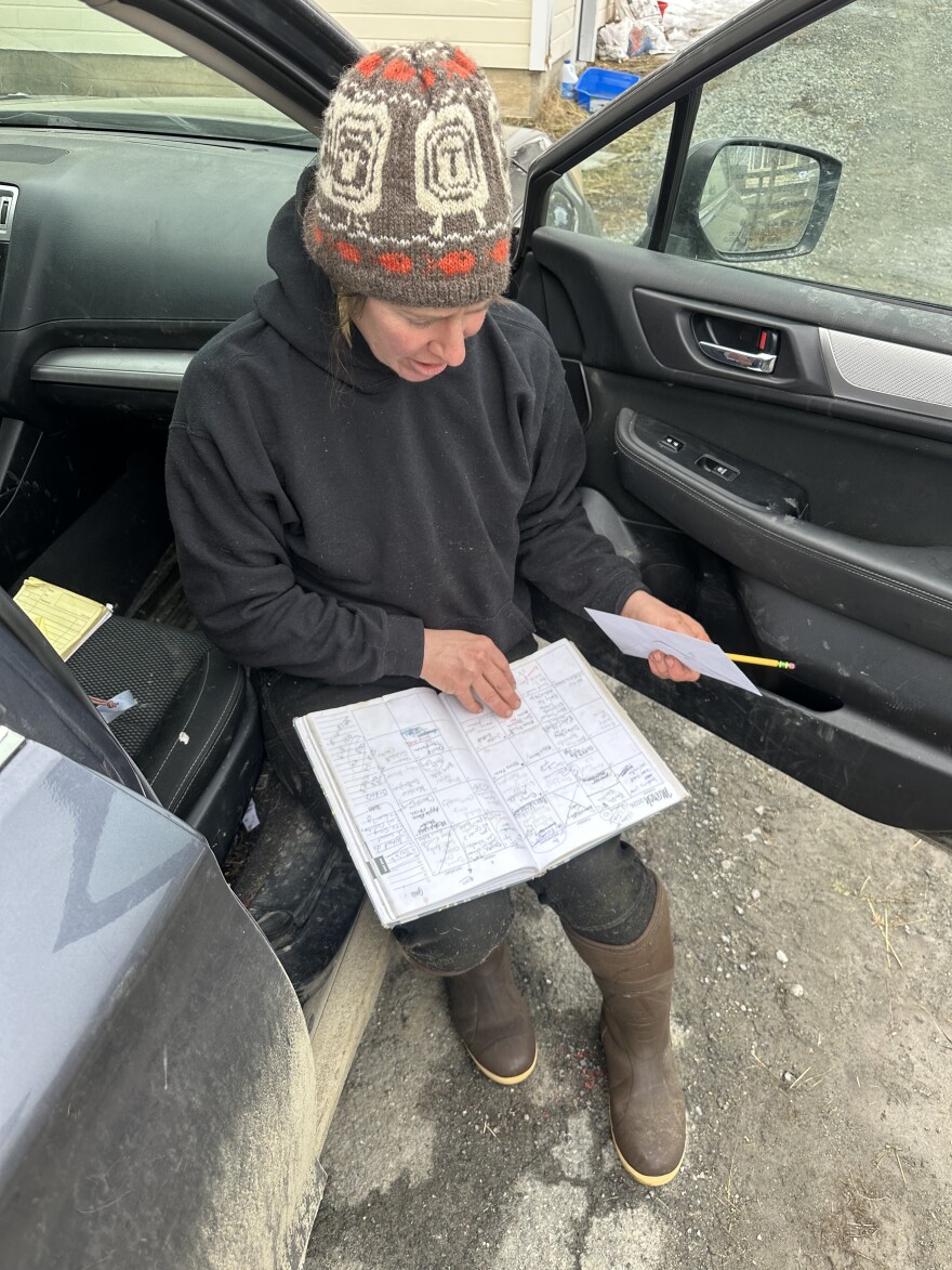 Woman in winter hat sitting in a car wtih a schedule book in her lap