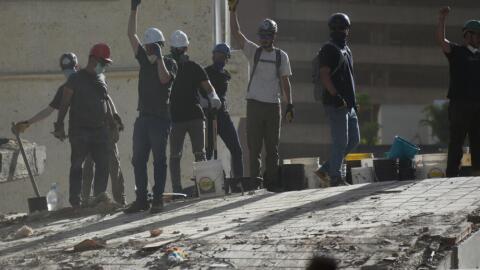 Rescue workers gesture for silence as they search for survivors in a building that collapsed after earthquakes struck Caracas, Venezuela, a day earlier, Thursday, June 25, 2026. (Jonathan Lanza/AP)