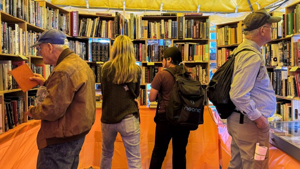 People walk and browse books.
