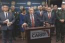 Paul Renner standing at the podium with Constitutional Carry on the front, surrounded by law enforcement