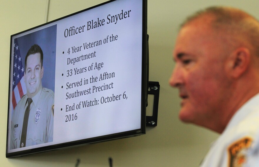 St. Louis County Police Chief Jon Belmar gives details of a shooting death of Officer Blake Snyder as a photo of the officer is shown during a press conference in Clayton. 10-06-16