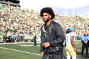 Oregon quarterback Dante Moore walking on a football field.