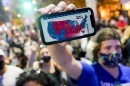 A supporter of President-elect Joe Biden holds up his mobile phone to display the Electoral College map outside the Philadelphia Convention Center after the 2020 presidential election is called on Nov. 7.